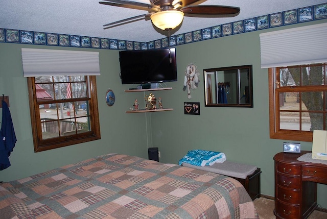 bedroom with carpet, ceiling fan, and a textured ceiling