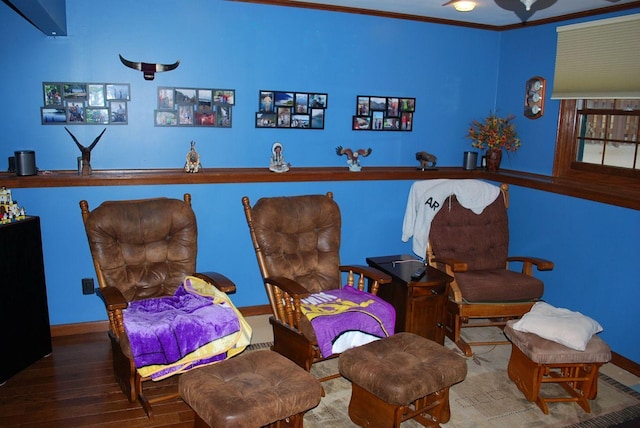 living area featuring wood-type flooring and crown molding