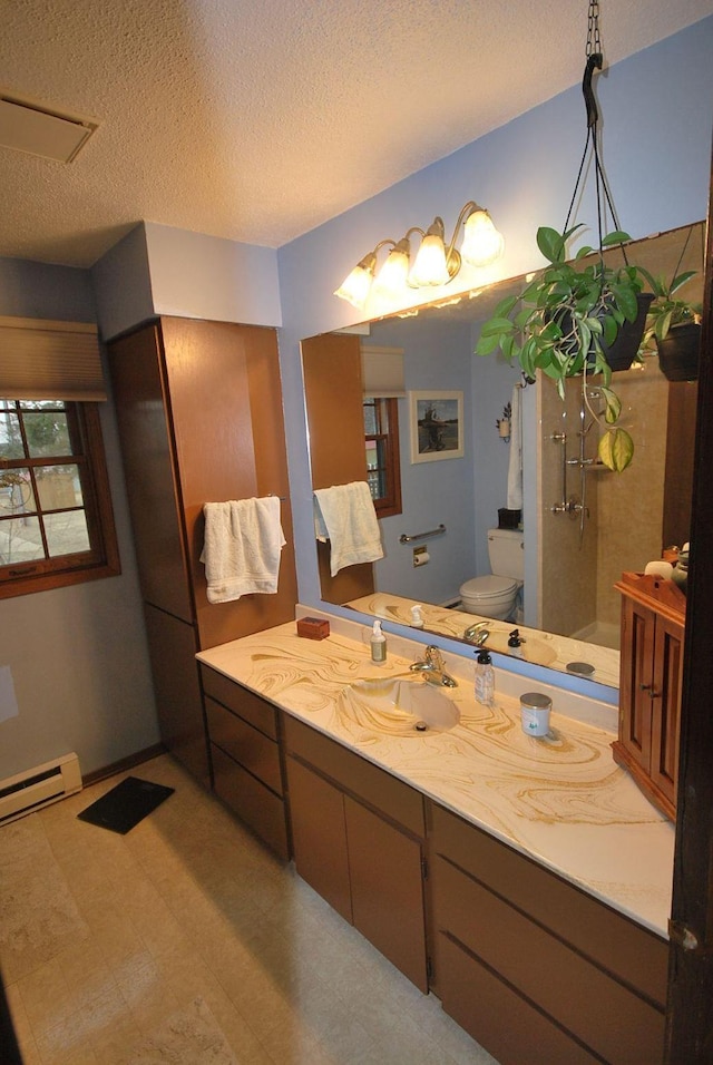 bathroom featuring vanity, toilet, baseboard heating, a textured ceiling, and walk in shower