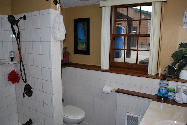 bathroom featuring vanity, a tile shower, a textured ceiling, and toilet