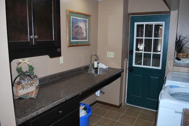 doorway featuring dark tile patterned floors, sink, and washer / clothes dryer