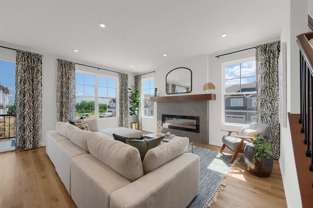 living room with a fireplace, light wood-type flooring, and a wealth of natural light