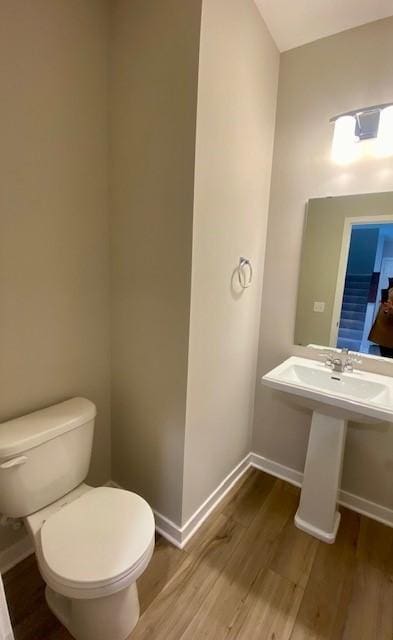 bathroom with sink, hardwood / wood-style floors, and toilet