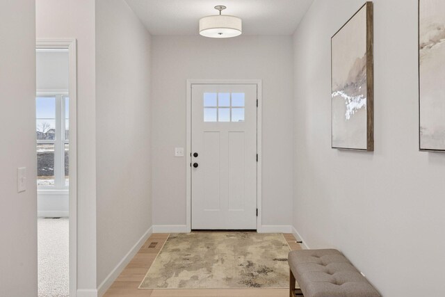 entryway featuring light wood-style flooring and baseboards