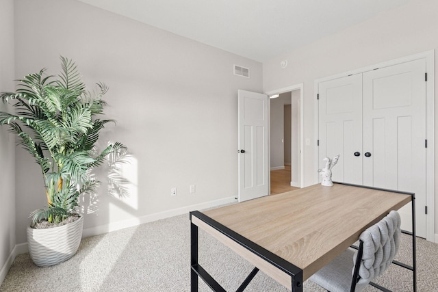 home office with baseboards, visible vents, and light carpet