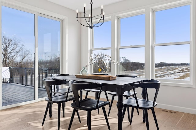 dining room with baseboards, visible vents, a chandelier, and light wood-type flooring