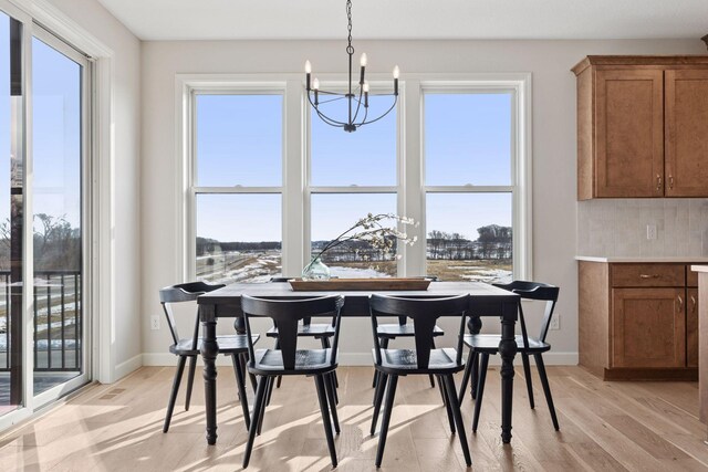 dining room with light wood-style floors, baseboards, and a chandelier