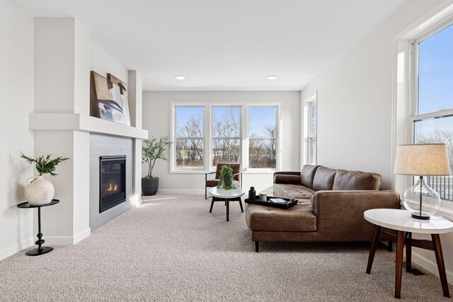 living room featuring a tiled fireplace, recessed lighting, baseboards, and carpet floors