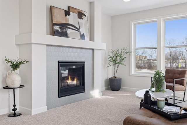 living room featuring baseboards, carpet floors, and a glass covered fireplace