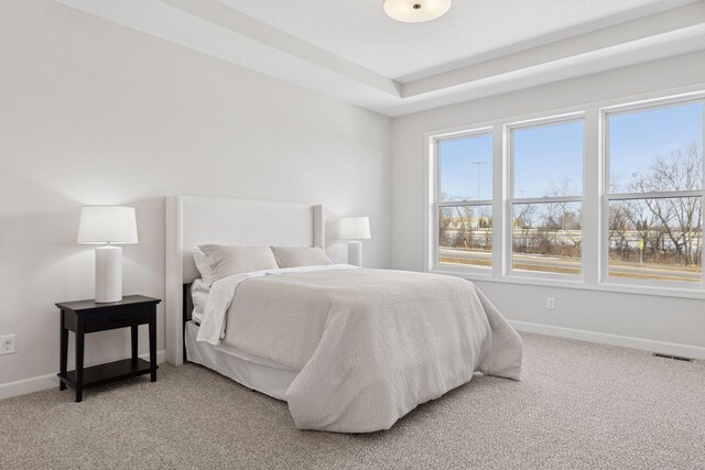 bedroom with baseboards, light carpet, and visible vents