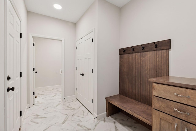 mudroom with recessed lighting, marble finish floor, and baseboards