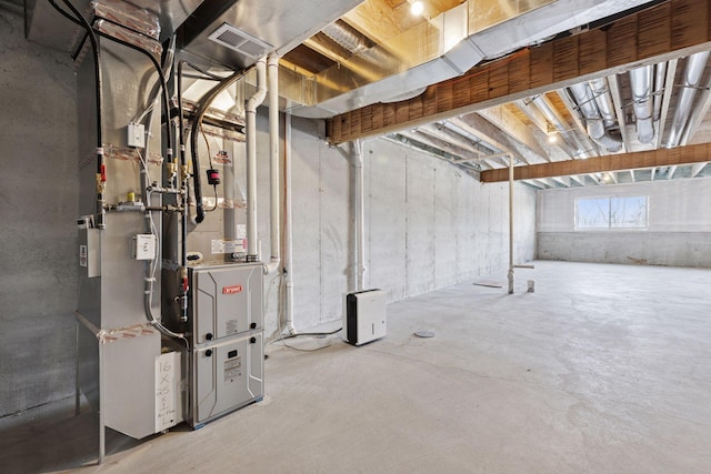 basement with visible vents and heating unit