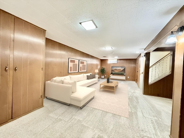 carpeted living room with wood walls