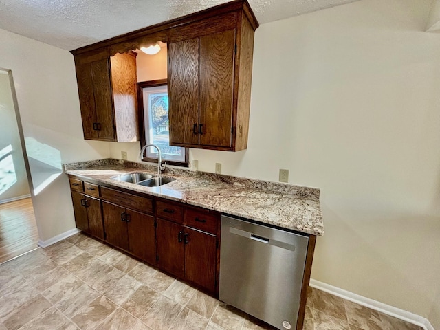 kitchen featuring dark brown cabinetry, sink, light stone countertops, and dishwasher