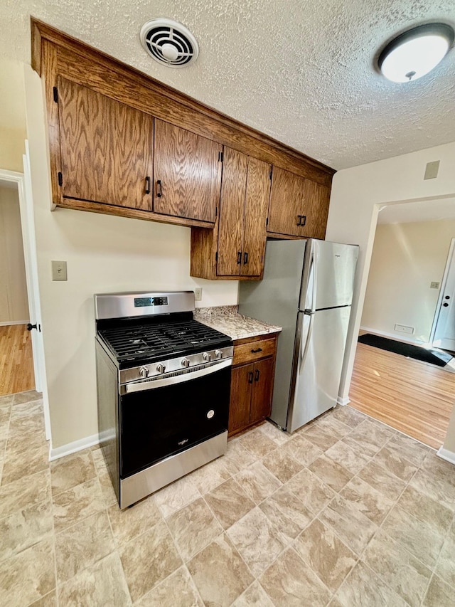 kitchen with a textured ceiling and appliances with stainless steel finishes