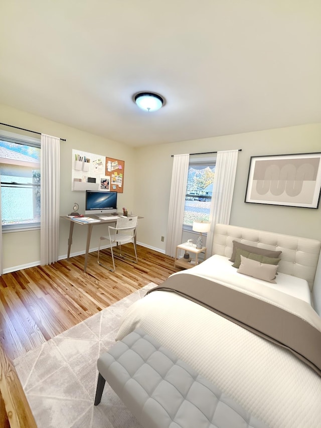 bedroom with multiple windows and wood-type flooring