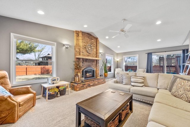 living area with a ceiling fan, vaulted ceiling, carpet floors, a brick fireplace, and recessed lighting