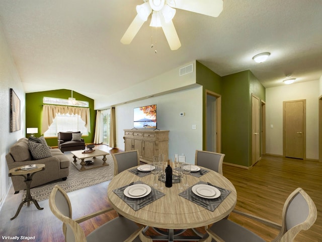 dining area featuring vaulted ceiling, hardwood / wood-style floors, and ceiling fan