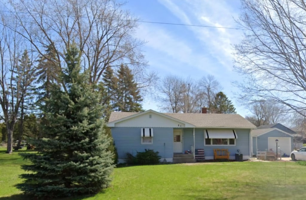 back of property with central air condition unit and a yard