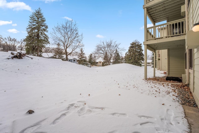 yard covered in snow with a balcony