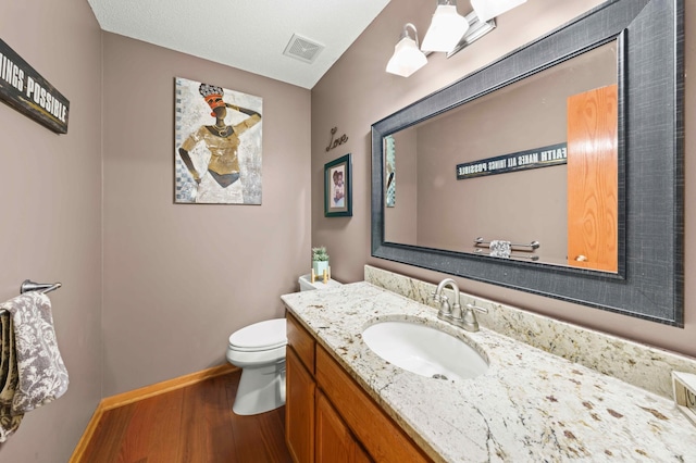 bathroom featuring hardwood / wood-style flooring, vanity, and toilet