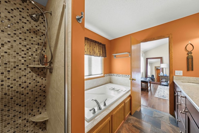 bathroom with a textured ceiling, vanity, lofted ceiling, and independent shower and bath