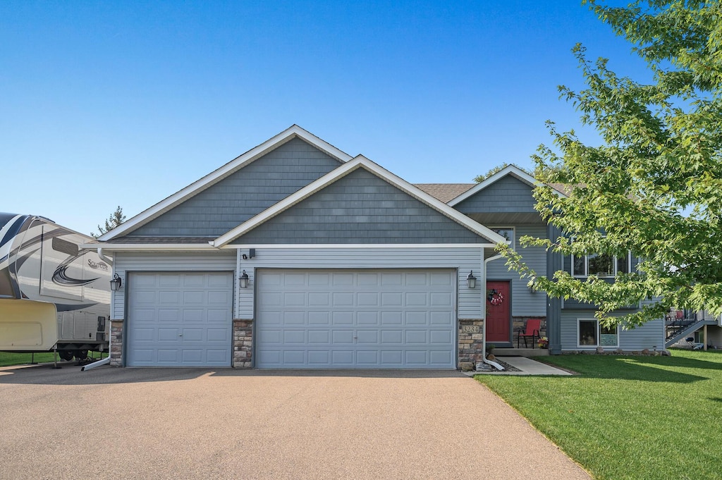 craftsman inspired home featuring a garage and a front lawn