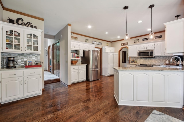 kitchen featuring white cabinets, appliances with stainless steel finishes, decorative backsplash, and pendant lighting