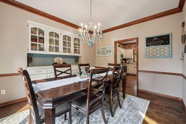 dining area featuring dark hardwood / wood-style floors, ornamental molding, and a chandelier