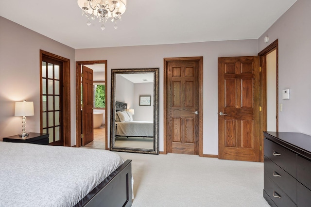 bedroom featuring ensuite bathroom, light carpet, and an inviting chandelier