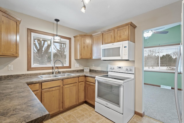 kitchen featuring ceiling fan, white appliances, hanging light fixtures, and sink