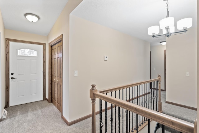 entryway with light carpet and a notable chandelier