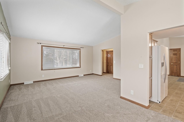 unfurnished room featuring light colored carpet and vaulted ceiling