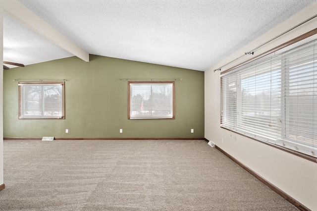 carpeted empty room with vaulted ceiling with beams, ceiling fan, and a textured ceiling