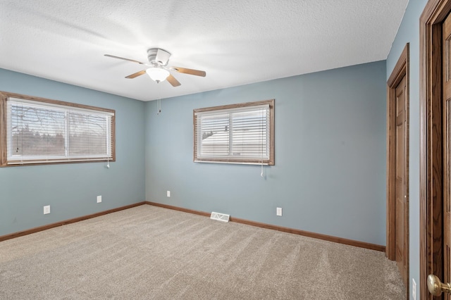 unfurnished bedroom featuring carpet flooring, ceiling fan, and a textured ceiling