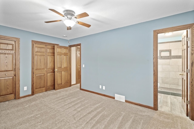 unfurnished bedroom with ensuite bath, ceiling fan, and light colored carpet