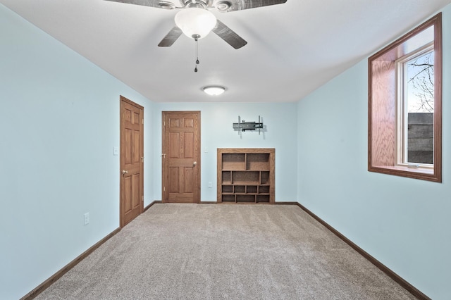 carpeted empty room featuring ceiling fan