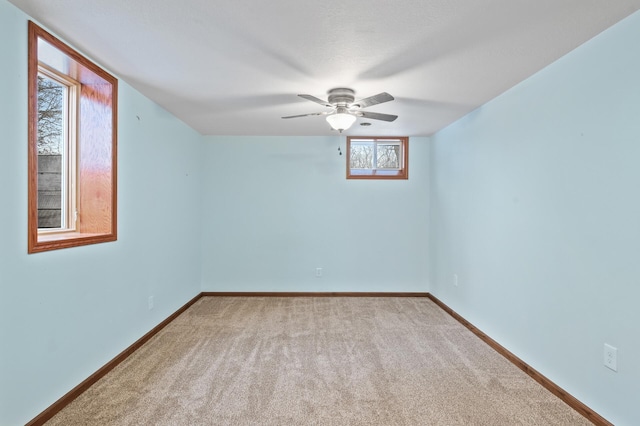 empty room featuring ceiling fan and light colored carpet