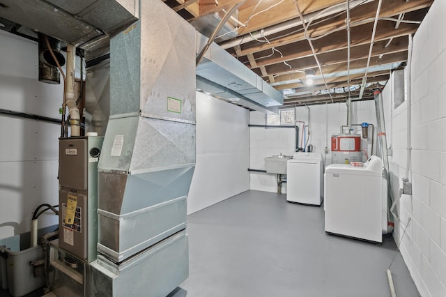 basement featuring washer and dryer, heating unit, and sink