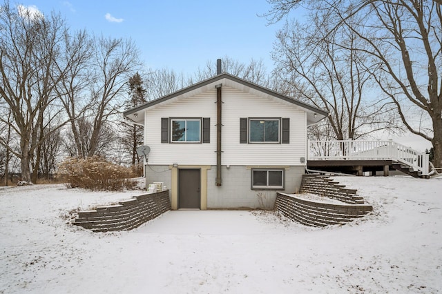 snow covered property with a wooden deck