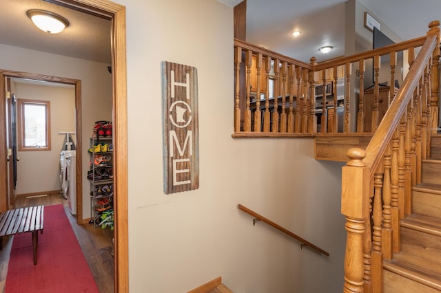 staircase featuring separate washer and dryer and wood-type flooring