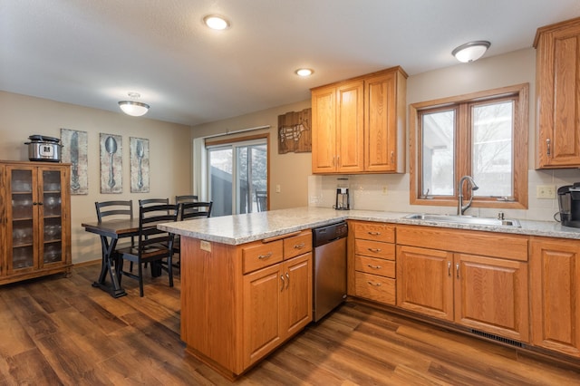 kitchen featuring dark hardwood / wood-style floors, stainless steel dishwasher, kitchen peninsula, and sink