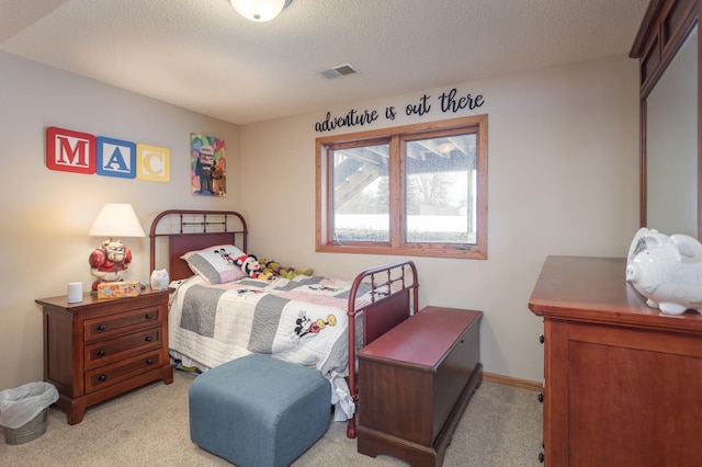 bedroom with light carpet and a textured ceiling