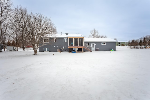 snow covered property featuring a sunroom