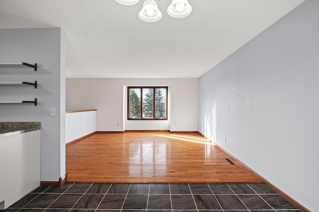 unfurnished living room with dark wood-type flooring and a notable chandelier