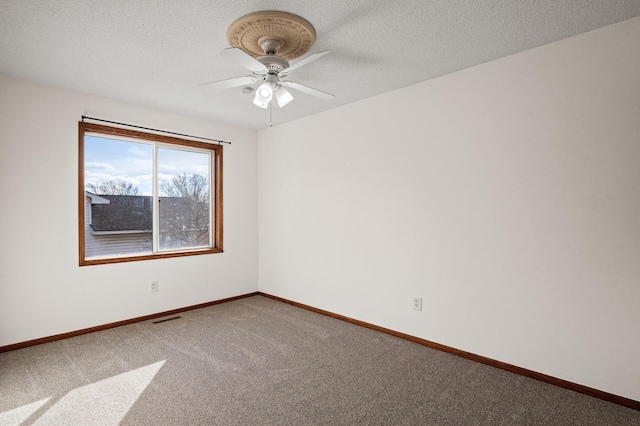 carpeted empty room with ceiling fan and a textured ceiling