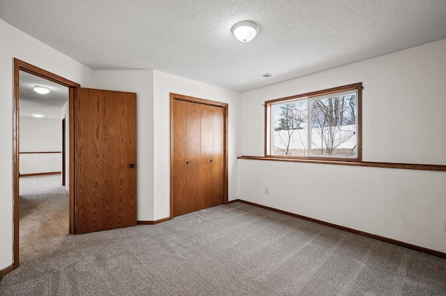 unfurnished bedroom with carpet floors, a textured ceiling, and a closet