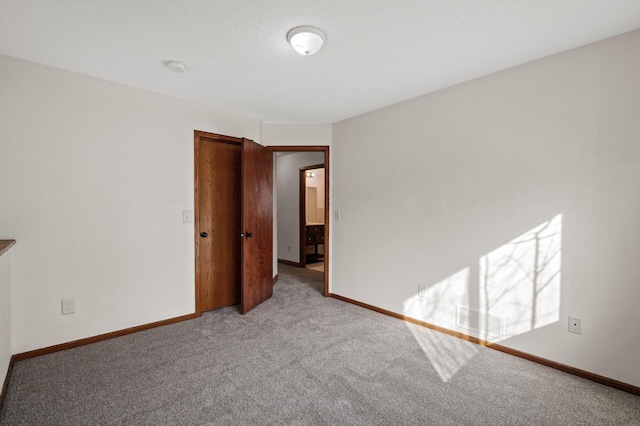 carpeted spare room with a textured ceiling