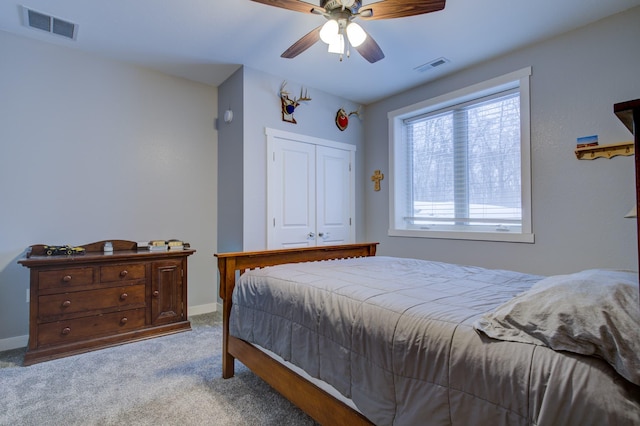 bedroom with ceiling fan, light carpet, and a closet