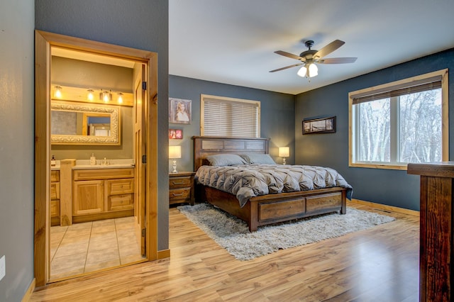 bedroom featuring connected bathroom, ceiling fan, sink, and light hardwood / wood-style floors